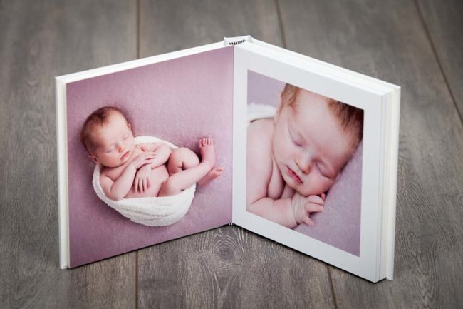 Open portrait book with newborn images